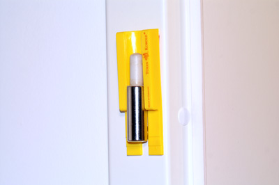 1. Schritt  Schieben Sie den Türen Kobold von oben bis zum Anschlag zwischen das untere Scharnierunterteilteil an dem Türrahmen bzw. an der Türzarge.